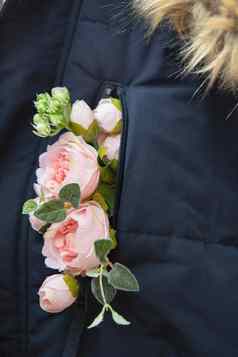 花束粉红色的花棒口袋里冬天蓝色的夹克