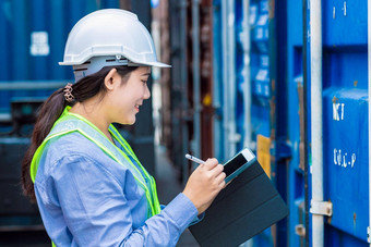 快乐女人工人工作港口航运货物物流检查管理进口出口货物容器平板电脑