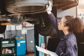 女人车库工人维护检查表<strong>汽车</strong>服务中心女<strong>汽车机械师</strong>车技术员工作服务检查修复客户车检查车罩