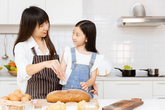 妈妈。孩子女孩烹饪食物首页厨房孩子烘焙首页使面包好快乐妈妈假期活动