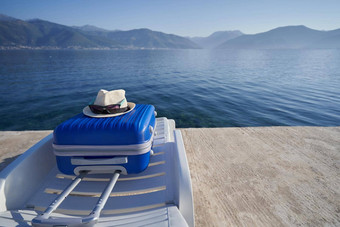 蓝色的手提箱太阳懒人海岸亚得里亚海海黑山共和国旅行概念