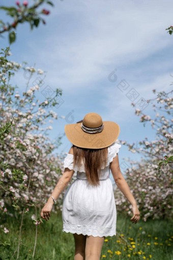 年轻的高加索人女人享受开花苹果树