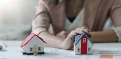 财产保险房子模型保护手真正的房地产概念
