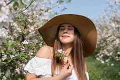 年轻的高加索人女人享受开花苹果树