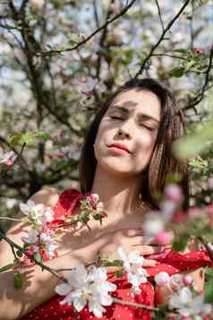 年轻的高加索人女人享受开花苹果树