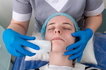 年轻的女人接收电电抗衰老脸水疗中心按摩美沙龙