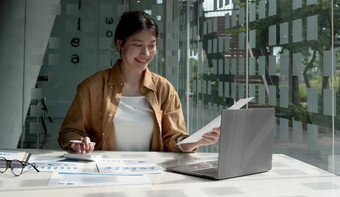 年轻的亚洲女商人快乐工作现代办公室移动PC计算器工作项目检查金融文档