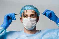古怪的微笑医生外科医生疯狂的情绪年轻的医生持有医疗剪刀