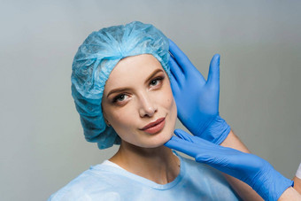 咨询塑料外科医生白色背景化妆品振兴面部治疗医生男人。蓝色的医疗手套触摸女孩脸