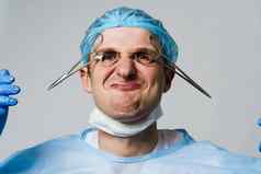 古怪的微笑医生外科医生疯狂的情绪年轻的医生持有医疗剪刀