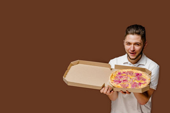 在线披萨安全交付服务餐厅年轻的有吸引力的快递男人。嗅探披萨舔嘴唇空空间做广告