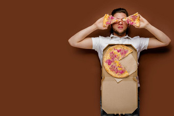 年轻的英俊的高加索人男人。了傻瓜块披萨有创意的的想法做广告比萨 店惊讶年轻的快递