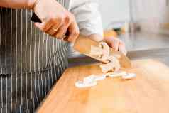 减少白色蘑菇拉面汤厨房老板厨师白色蘑菇刀餐厅切割白色蘑菇