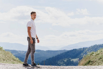 英俊的男人。走绿色山背景广告旅行机构旅游旅行山