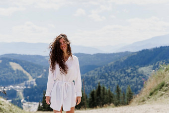 女孩旅行者微笑山有吸引力的女人摆姿势绿色山背景广告旅行机构旅游