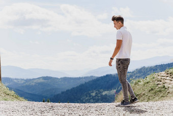 英俊的男人。走绿色山背景广告旅行机构旅游旅行山