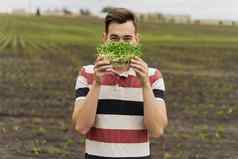 绿色microgreenvegeterian食物手英俊的男人。持有troughtmicrogreen向日葵种子场素食主义者食物交付