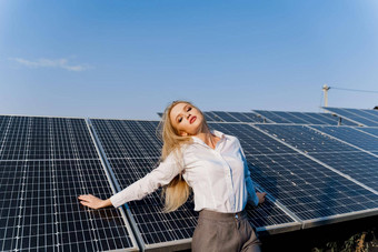女人倾斜太阳能面板金发女郎穿着白色正式的衬衫权力植物免费的电首页绿色能源