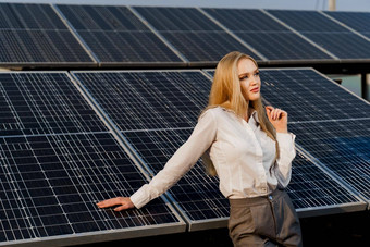 金发女郎模型太阳能面板站行地面女孩穿着白色正式的衬衫微笑权力植物绿色能源