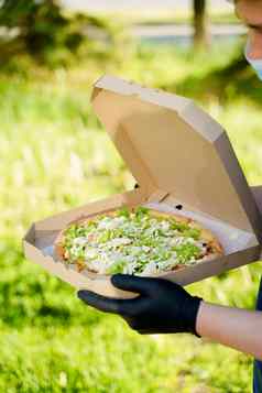 快递医疗面具手套持有披萨手披萨绿色沙拉西红柿奶酪