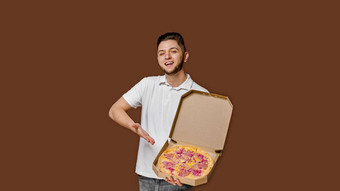 在线披萨安全交付服务餐厅年轻的英俊的快递男人。微笑点披萨空空间做广告