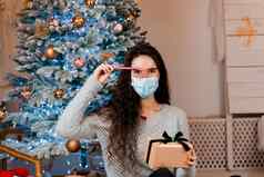 女孩医疗面具圣诞节现在糖果庆祝活动一年self-isolation流感大流行冠状病毒科维德概念广告出售检疫期