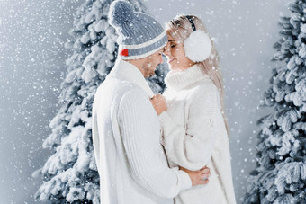 快乐年轻的夫妇拥抱微笑雪瀑布圣诞<strong>节</strong>树夏娃一年庆祝<strong>活动</strong>冬天一天笑脸<strong>男人</strong>。女人穿白色套头毛衣爱