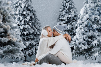 夫妇座位雪拥抱吻有趣的<strong>冬天</strong>爱故事一年庆祝活动等待圣诞节礼物快乐夫妇穿皮毛耳机帽子白色毛衣