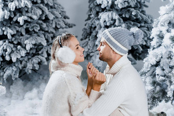 一年爱故事夫妇吻拥抱人穿穿皮毛耳机帽子白色毛衣快乐年轻的夫妇拥抱吻圣诞节树<strong>冬天</strong>一天