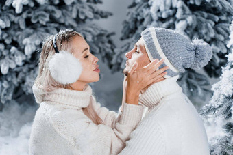 夫妇座位雪拥抱吻有趣的冬天爱故事一年庆祝活动等待圣诞节礼物快乐夫妇穿皮毛耳机帽子白色毛衣