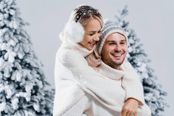 冬天爱故事夫妇穿皮毛耳机帽子白色毛衣快乐年轻的夫妇拥抱吻圣诞节树夏娃一年庆祝活动冬天一天