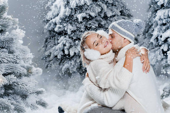 下降雪<strong>吻</strong>快乐年轻的夫妇特写镜头拥抱<strong>吻</strong>圣诞节树夏娃<strong>一</strong>年庆祝活动冬天<strong>一</strong>天笑脸男人。女人穿白色套头毛衣爱
