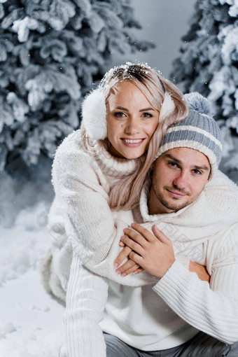 一年爱故事夫妇吻拥抱人穿穿皮毛耳机帽子白色毛衣快乐年轻的夫妇拥抱吻圣诞节树冬天一天