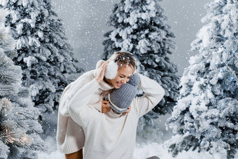 一年爱故事夫妇吻拥抱人穿穿皮毛耳机帽子白色毛衣快乐年轻的夫妇拥抱吻圣诞节树冬天一天