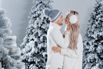 夫妇<strong>接吻</strong>圣诞节树冬天假期爱故事年轻的夫妇穿白色套头毛衣快乐<strong>男人</strong>。年轻的女人拥抱