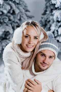 夫妇接吻圣诞节树冬天假期爱故事年轻的夫妇穿白色套头毛衣快乐男人。年轻的女人拥抱