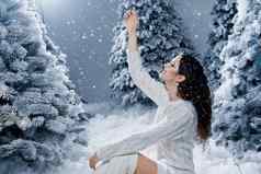 快乐女孩微笑触摸下降雪夏娃一年年轻的女人大雪梳理冬天一天圣诞节庆祝活动