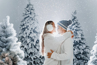 夫妇接吻雪瀑布圣诞节树<strong>冬天</strong>假期爱故事年轻的夫妇穿白色套头毛衣快乐男人。年轻的女人拥抱
