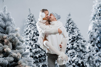 夫妇夫妇笑有趣的雪瀑布圣诞节树<strong>冬天</strong>假期爱故事年轻的夫妇穿白色套头毛衣快乐男人。年轻的女人拥抱