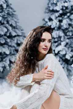有吸引力的女孩温暖的白色毛衣白色袜子雪树一年圣诞节假期
