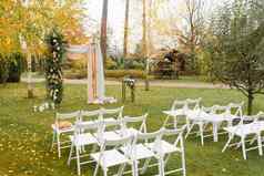 婚礼装饰婚姻仪式秋天白色椅子婚礼拱夫妇森林
