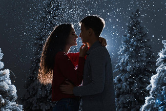 下降雪吻下降雪黑暗蓝色的背景快乐年轻的夫妇拥抱吻圣诞节树夏娃一年庆祝活动冬天一天