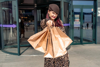 快乐购物狂女孩袋购物中心女人商店快乐购买持有袋穿着豹打印衣服消费者概念