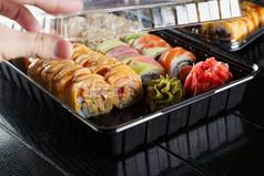 寿司卷食物交付服务寿司集盒子黑色的背景传统的日本海鲜美味的卷