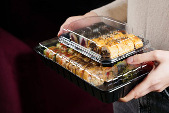 寿司卷食物交付服务持有寿司集盒子黑色的背景传统的日本海鲜美味的卷