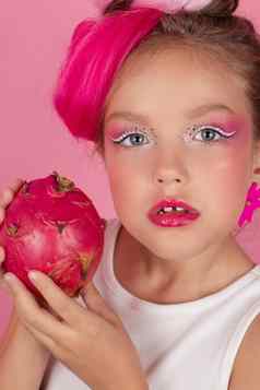 甜蜜的女孩持有Pitahaya脸火龙果水果持有手粉红色的背景热带龙水果减少一半空间文本