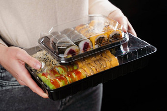 寿司卷食物交付服务持有寿司集盒子黑色的背景传统的日本海鲜美味的卷