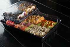 寿司卷食物交付服务寿司集盒子黑色的背景传统的日本海鲜美味的卷