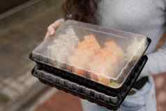 特写镜头寿司集盒子健康的食物交付在线服务女孩持有寿司集手