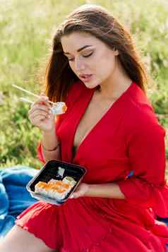 寿司嘴唇女孩蓝色的眼睛野餐食物交付日本餐厅垂直照片广告社会网络漂亮的女孩吃寿司集公园